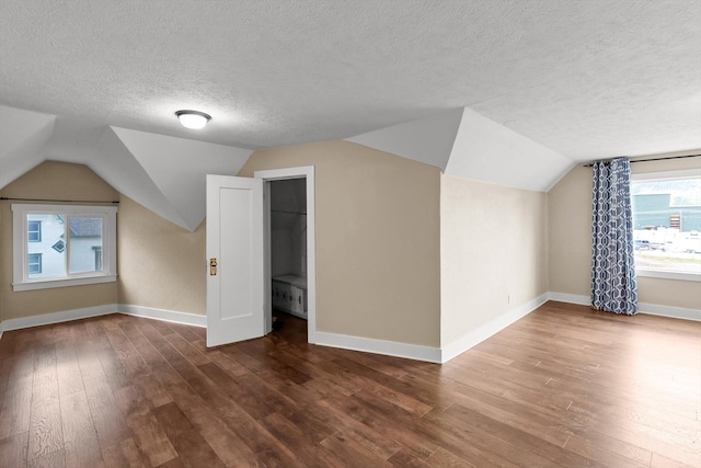 360 White House Ln, Bonner, MT 59823 - additional living space with a textured ceiling, vaulted ceiling, hardwood / wood-style floors, and baseboards