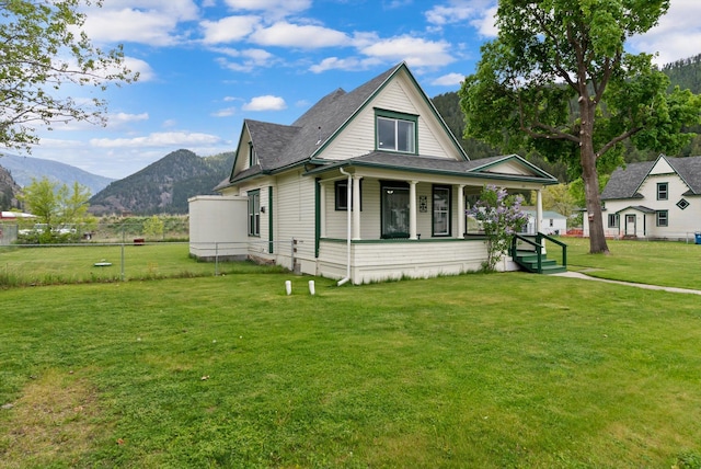 360 White House Ln, Bonner, MT 59823 - view of front of house with a porch, a mountain view, a front lawn, and roof with shingles
