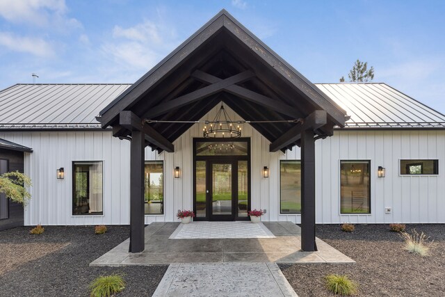 doorway to property featuring a standing seam roof, board and batten siding, and metal roof