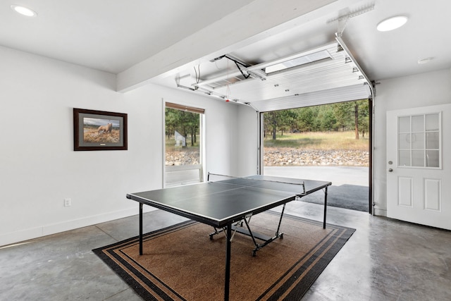 playroom featuring a garage, baseboards, and finished concrete flooring