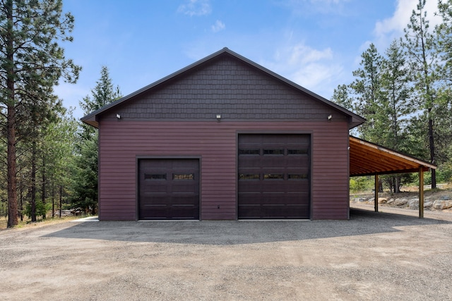garage with a detached garage and dirt driveway