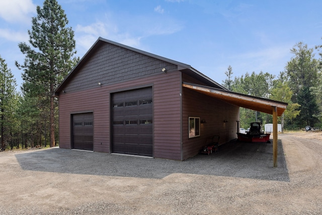 garage featuring dirt driveway and a detached garage