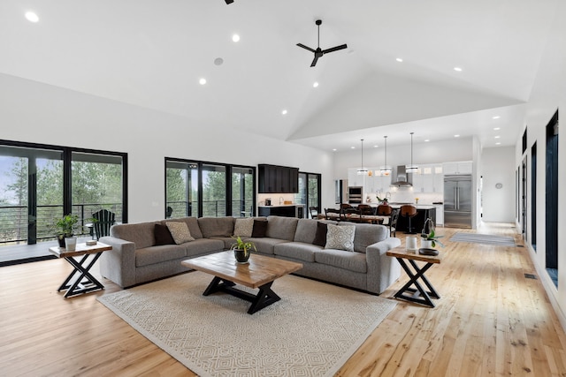 living area featuring high vaulted ceiling, ceiling fan, recessed lighting, and light wood-type flooring