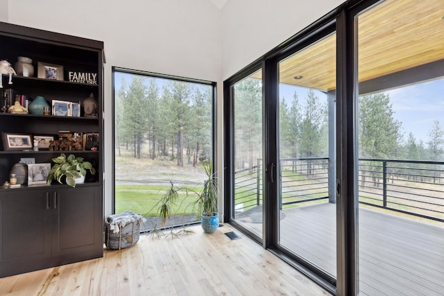 doorway to outside with a healthy amount of sunlight, wood finished floors, and visible vents