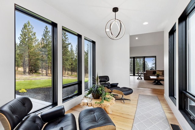 living area with light wood-style flooring, visible vents, and recessed lighting