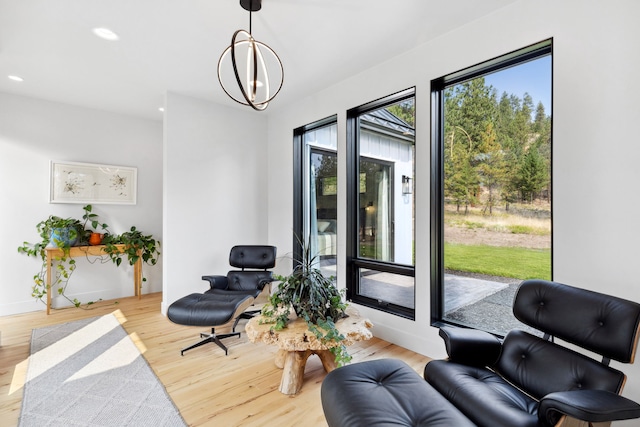 sitting room featuring recessed lighting, wood finished floors, and a notable chandelier