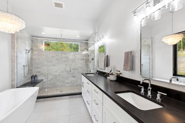 full bathroom with a freestanding tub, a sink, a shower stall, and double vanity
