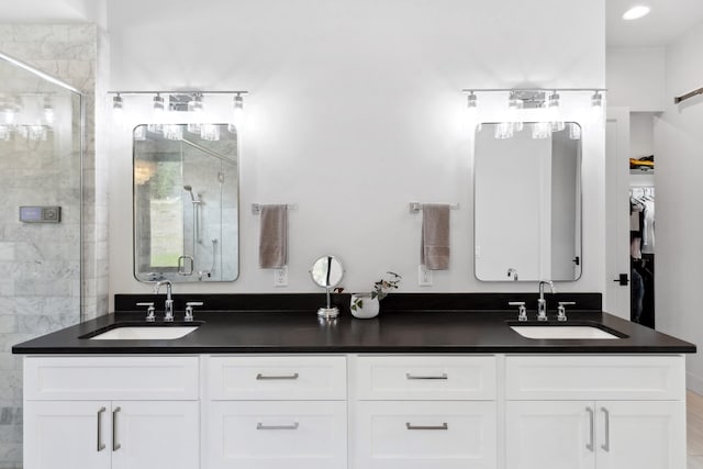 full bathroom featuring a sink, double vanity, and a stall shower