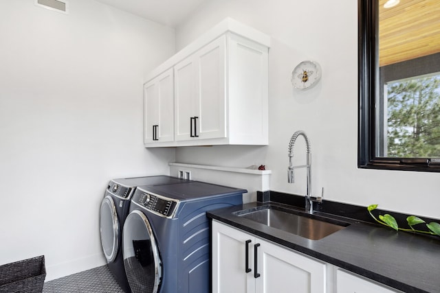 washroom with a sink, separate washer and dryer, cabinet space, carpet, and visible vents