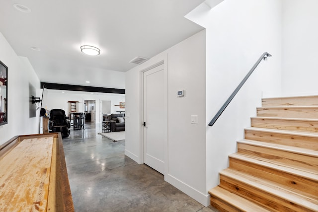 stairway featuring concrete flooring, visible vents, and baseboards