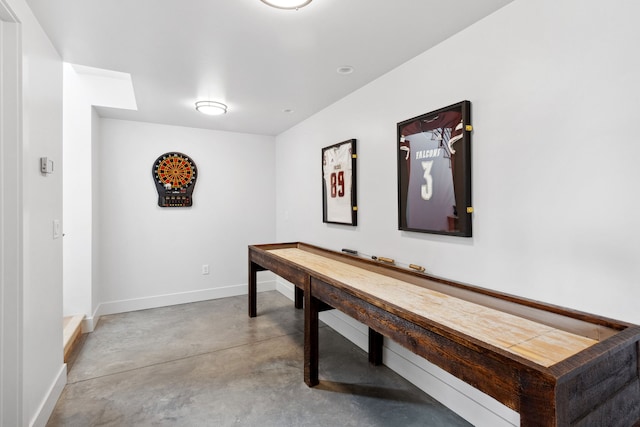 rec room featuring baseboards and finished concrete floors