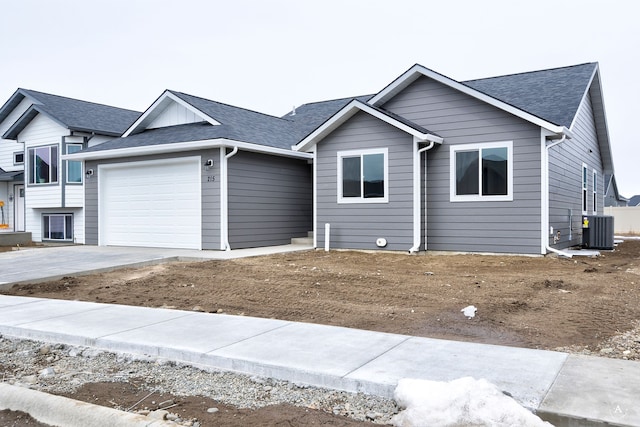 215 Meadow View Loop, East Helena, MT 59635 - ranch-style house featuring concrete driveway, roof with shingles, central AC, and a garage