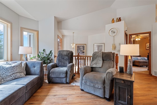 515 Country Way, Kalispell, MT 59901 - living room with lofted ceiling, light wood-style flooring, ceiling fan, and a chandelier