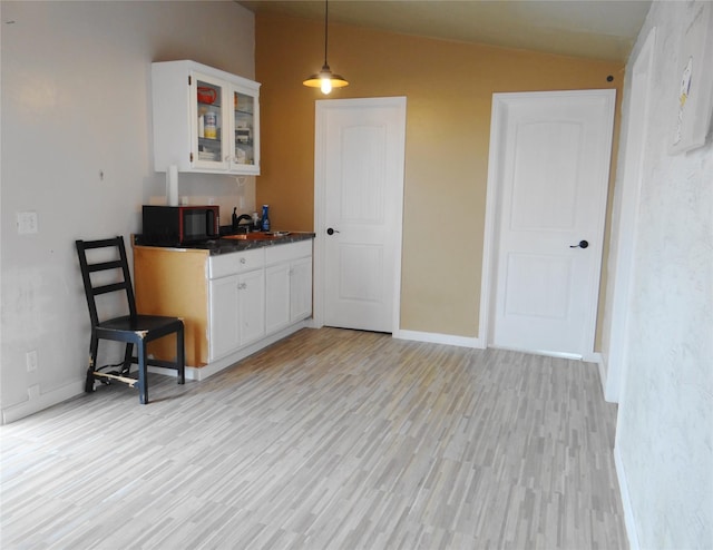 652 Simms Ashuelot Rd, Fort Shaw, MT 59443 - kitchen with black microwave, vaulted ceiling, a sink, white cabinets, and glass insert cabinets