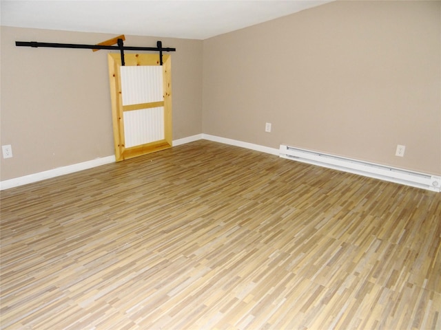 652 Simms Ashuelot Rd, Fort Shaw, MT 59443 - empty room featuring light wood-type flooring, a barn door, baseboards, and a baseboard heating unit