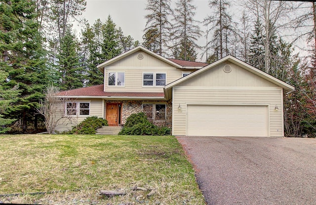 traditional-style home with an attached garage, driveway, and a front yard