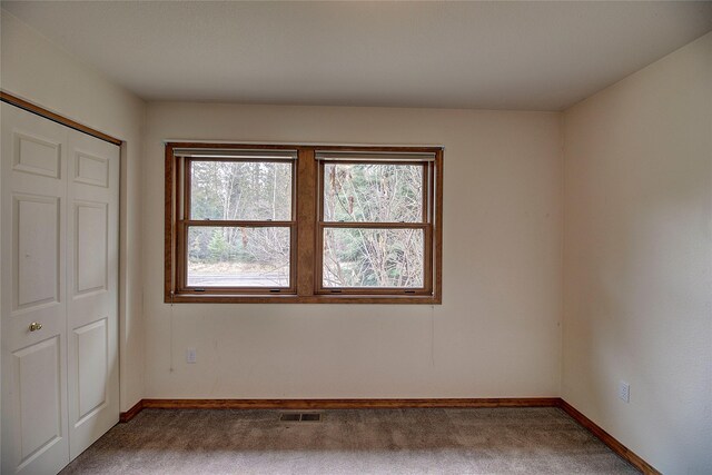 spare room featuring visible vents, baseboards, and carpet