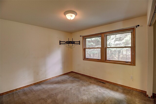 unfurnished room featuring baseboards, carpet flooring, and visible vents