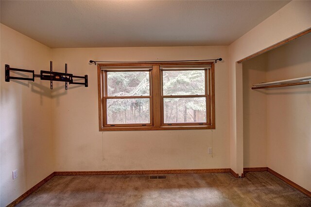 unfurnished bedroom with baseboards, visible vents, carpet, and a closet