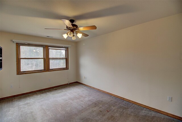 unfurnished room with baseboards, a ceiling fan, visible vents, and light colored carpet
