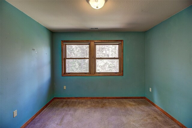 carpeted empty room featuring visible vents and baseboards