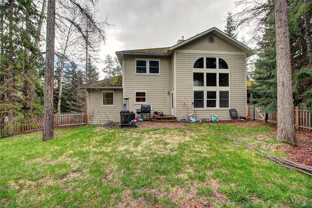 back of property featuring a yard and a fenced backyard