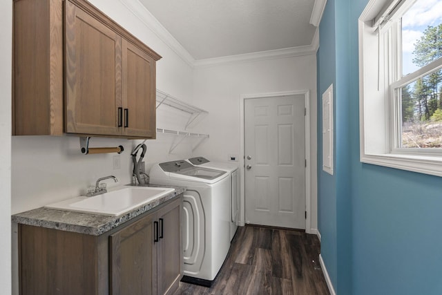 clothes washing area featuring washer and clothes dryer, a sink, cabinet space, dark wood-type flooring, and ornamental molding