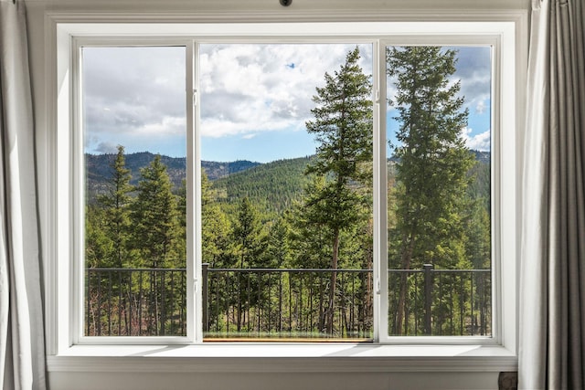 doorway to outside featuring a wooded view and a mountain view