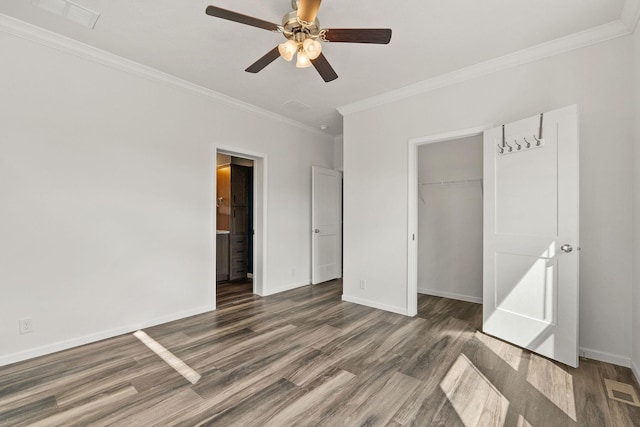 unfurnished bedroom featuring wood finished floors, visible vents, ornamental molding, a closet, and baseboards