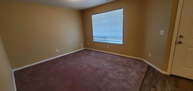 1034 Main St, Corvallis, MT 59828 - empty room featuring dark colored carpet and baseboards