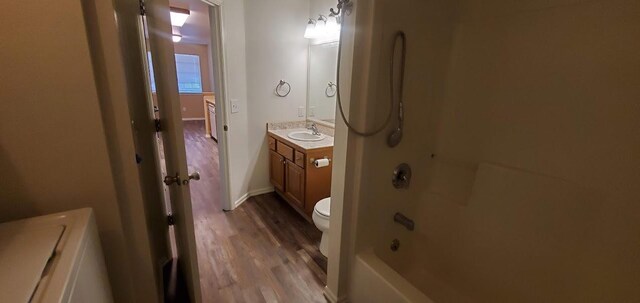 1034 Main St, Corvallis, MT 59828 - bathroom with toilet, vanity, wood finished floors, and shower / bathing tub combination