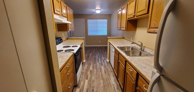 1034 Main St, Corvallis, MT 59828 - kitchen featuring electric stove, a sink, under cabinet range hood, dark wood-style flooring, and freestanding refrigerator