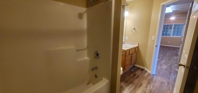 1034 Main St, Corvallis, MT 59828 - bathroom with shower / bathing tub combination, baseboards, wood finished floors, and vanity