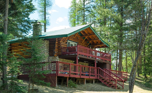 2025 Emmons Canyon Rd, Kila, MT 59920 - rear view of property featuring log exterior, a chimney, a deck, and metal roof