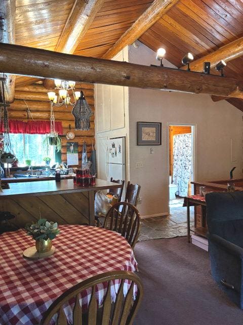 carpeted dining space featuring wood ceiling, vaulted ceiling with beams, a notable chandelier, and rustic walls