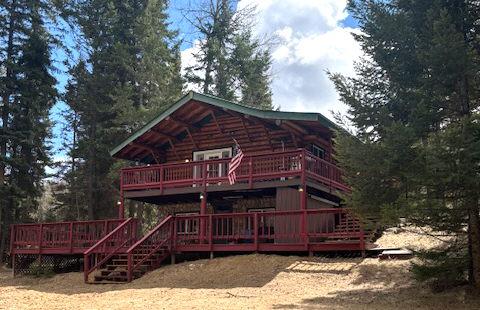 rear view of property featuring stairway and a deck