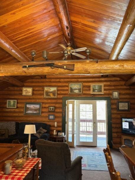 2025 Emmons Canyon Rd, Kila, MT 59920 - carpeted living room with rustic walls, ceiling fan, and wooden ceiling