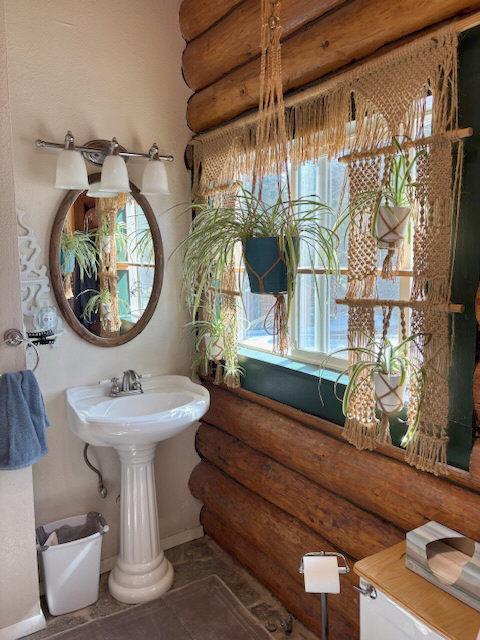 2025 Emmons Canyon Rd, Kila, MT 59920 - bathroom featuring rustic walls, baseboards, and tile patterned floors