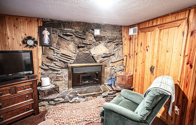 2025 Emmons Canyon Rd, Kila, MT 59920 - living room with wood walls, a textured ceiling, carpet floors, and a fireplace