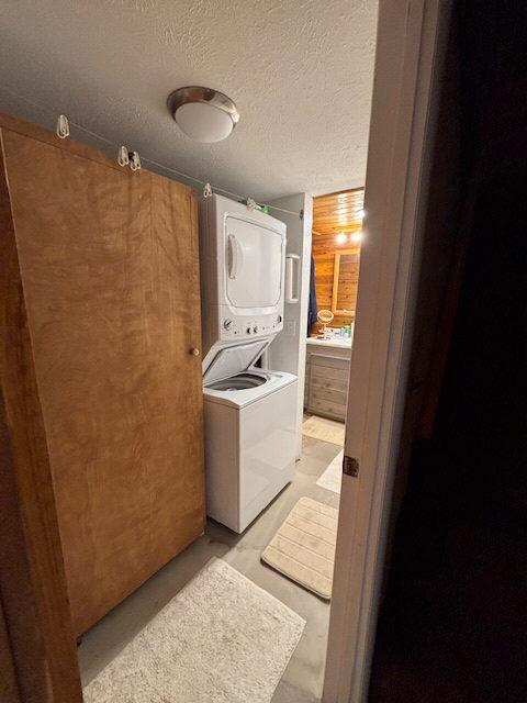 2025 Emmons Canyon Rd, Kila, MT 59920 - washroom featuring stacked washing machine and dryer and a textured ceiling