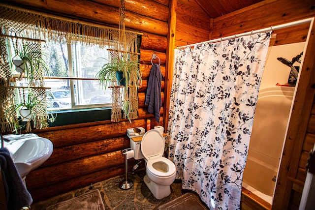 full bath with toilet, a shower with curtain, and rustic walls