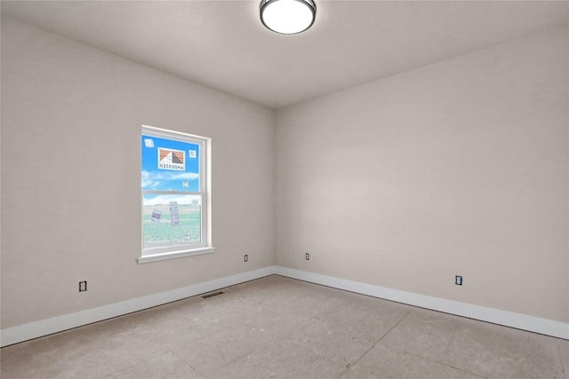 empty room featuring baseboards and visible vents