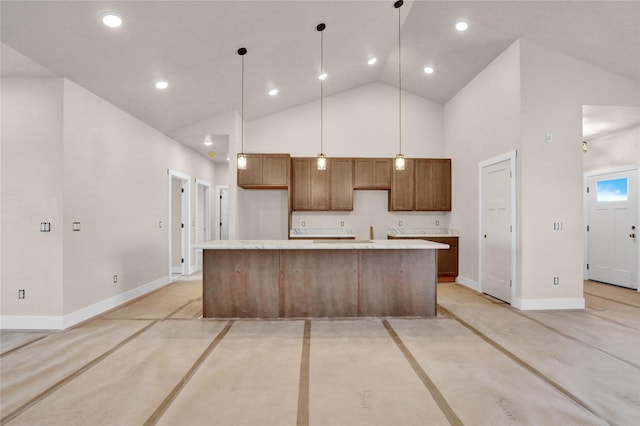 kitchen featuring high vaulted ceiling, light countertops, decorative light fixtures, baseboards, and a kitchen island