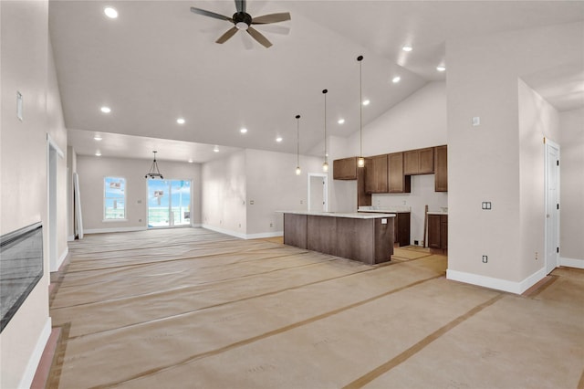 kitchen featuring open floor plan, a center island, baseboards, and ceiling fan