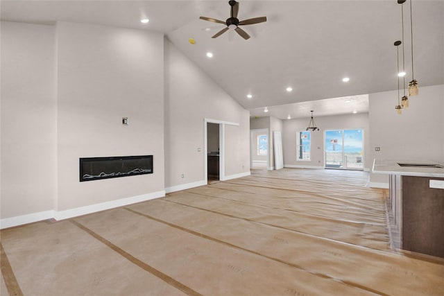 unfurnished living room with recessed lighting, finished concrete flooring, and baseboards