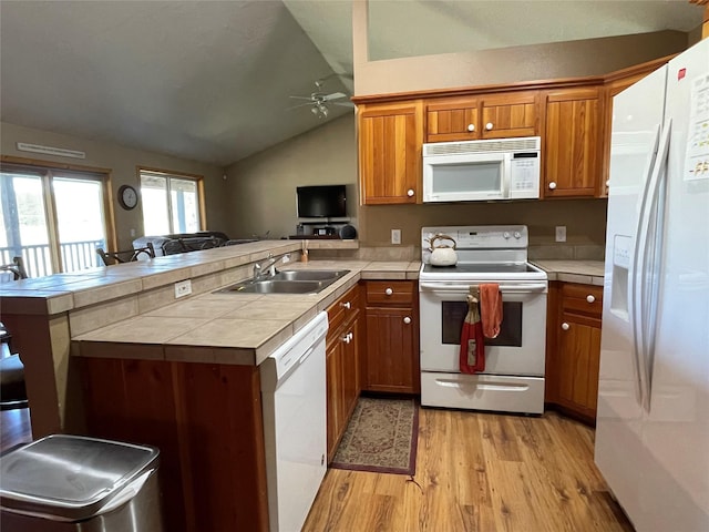 398 Little Beaver Creek Rd, Trout Creek, MT 59874 - kitchen featuring a peninsula, light wood-style flooring, a sink, white appliances, and brown cabinetry