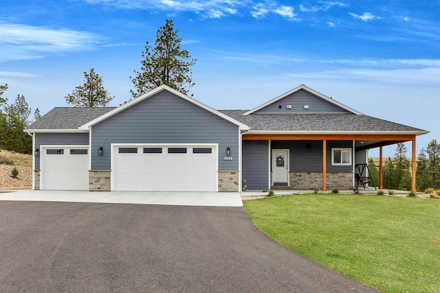 view of front facade with stone siding, driveway, a front yard, and a garage