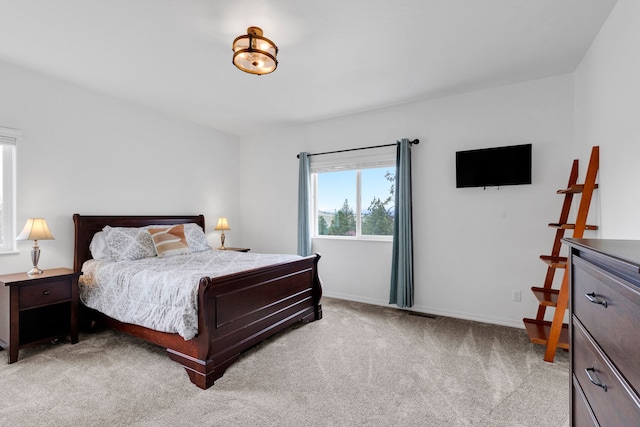 bedroom featuring light carpet and baseboards