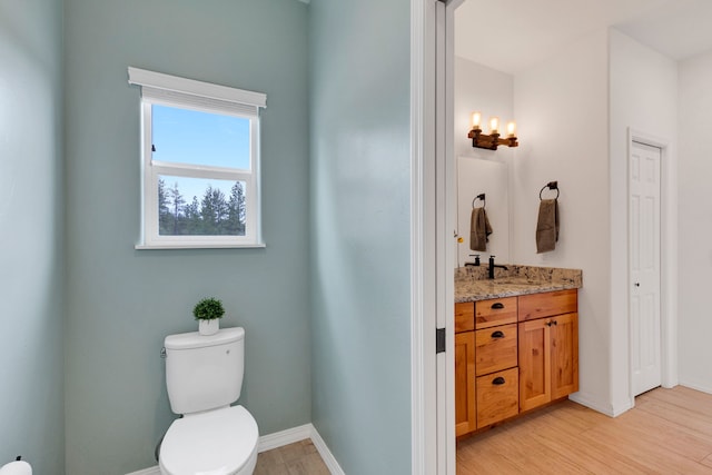 bathroom with baseboards, vanity, and toilet