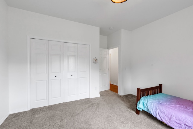 bedroom with baseboards, carpet flooring, and a closet